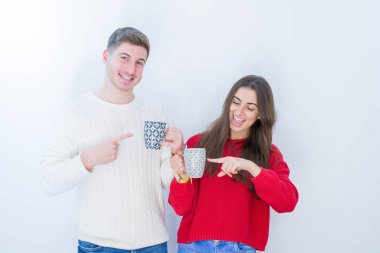 Beyaz izole arka plan üzerinde güzel genç çift el ve parmak ile işaret kahve çok mutlu bir fincan içme
