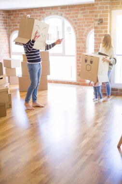 Yeni evde karton bel kutuları ile oynayan çocuk ile güzel famiily