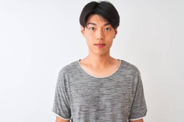 Genç Çinli adam ciddi düşünme akıllı yüz üzerinde kendine güvenen bir ifade ile izole beyaz arka plan üzerinde duran rahat t-shirt giyen