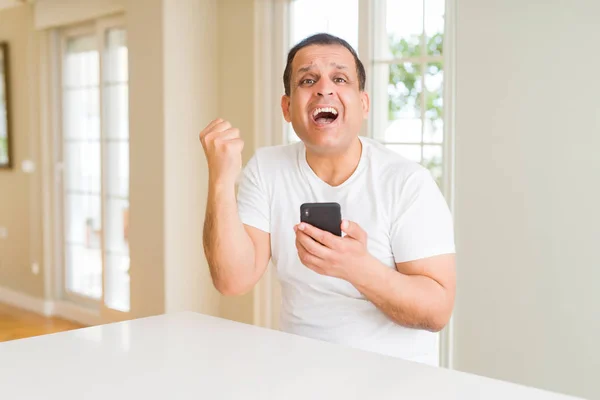 Uomo Mezza Età Utilizzando Smartphone Casa Urlando Orgoglioso Celebrando Vittoria — Foto Stock