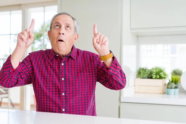 Hombre Mayor Guapo Casa Asombrado Sorprendido Mirando Hacia Arriba Señalando — Foto de Stock