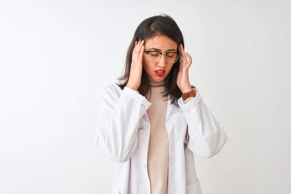 Chinese doctor woman wearing coat and pink stethoscope over isolated white background with hand on head for pain in head because stress. Suffering migraine.
