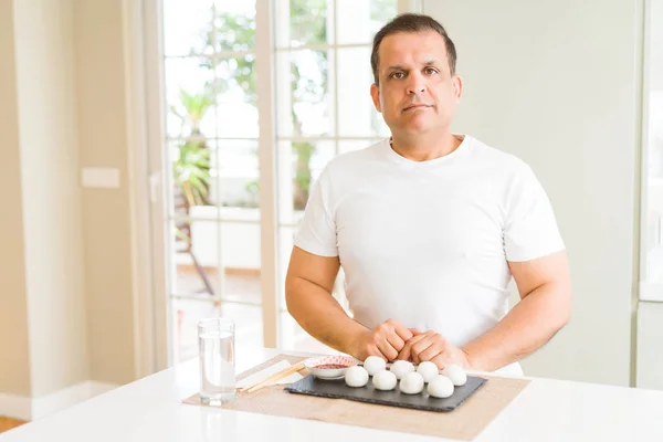 Hombre Mediana Edad Comiendo Albóndigas Asiáticas Casa Con Expresión Seria — Foto de Stock