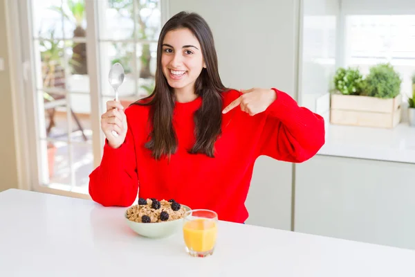 健康的なシリアルとベリーを朝食に持つ美しい若い女性は 驚きの顔で自分自身を指差す — ストック写真