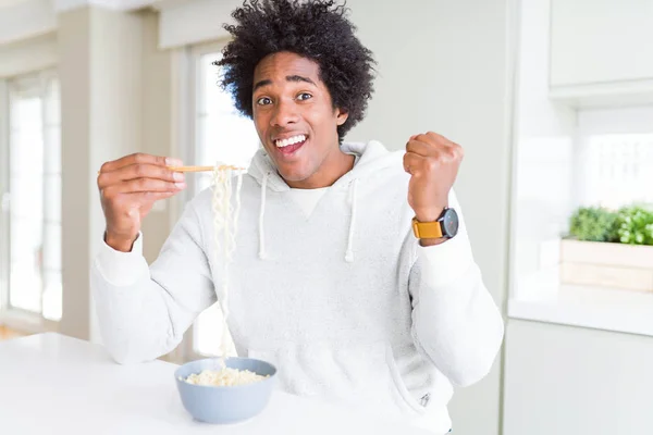 Hombre Afroamericano Comiendo Fideos Asiáticos Usando Palillos Casa Gritando Orgulloso — Foto de Stock