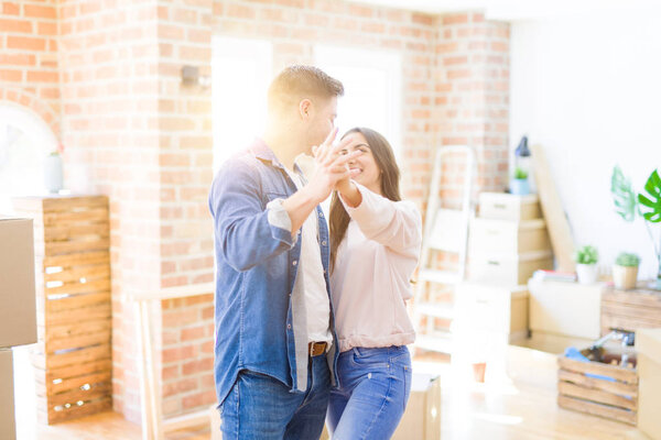 Beautiful young couple having fun dancing at new apartment, cele