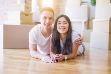 Genç güzel çift karton kutular etrafında yeni evde yatarken