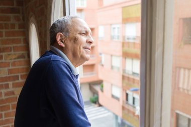 Yakışıklı orta yaş kıdemli neşeli, mutlu gülümseyen adam ve yerine koymak