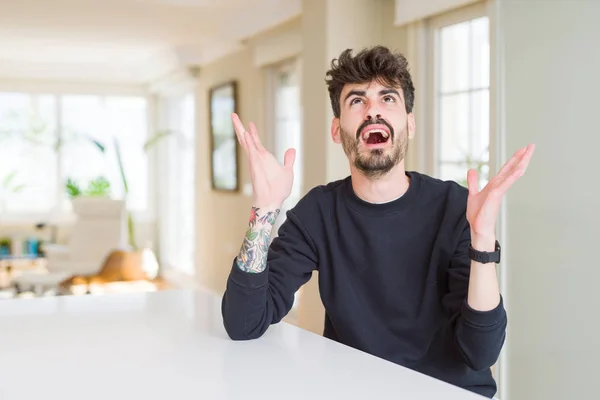 Hombre Joven Con Sudadera Casual Sentado Mesa Blanca Loco Loco — Foto de Stock