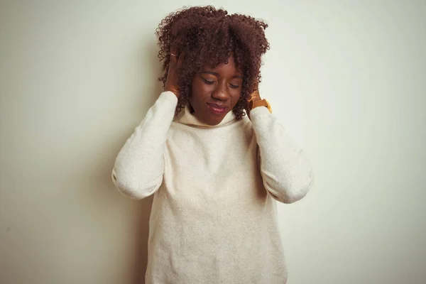 孤立した白い背景の上にタートルネックのセーターを着た若いアフリカのアフロ女性は 頭痛に苦しんで絶望的で 痛みと偏頭痛のためにストレスを受けました 頭の上に手を置く — ストック写真