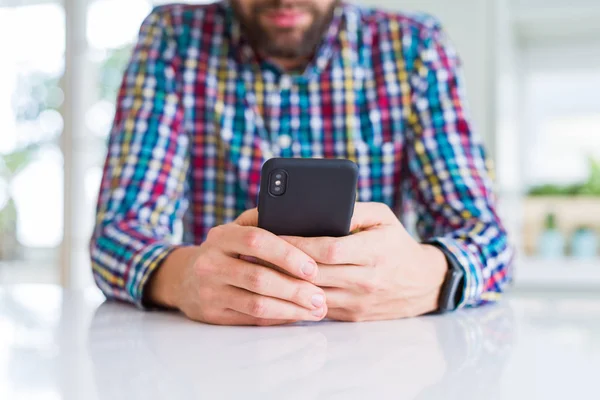 Primer plano de las manos del hombre usando el teléfono inteligente y sonriendo —  Fotos de Stock