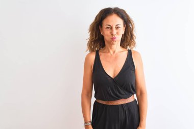 Orta yaş kadın komik yüzü ile izole beyaz arka plan şişme yanakları üzerinde duran siyah rahat elbise giyiyor. Ağız hava ile şişirilmiş, deli ifade.