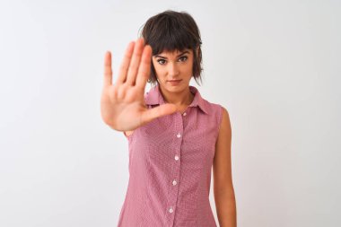 Kırmızı yazlık gömlek giyen genç güzel kadın izole beyaz arka plan üzerinde duran avuç içi ile şarkı durdurmak yapıyor. Yüzünde olumsuz ve ciddi bir jest olan uyarı ifadesi.