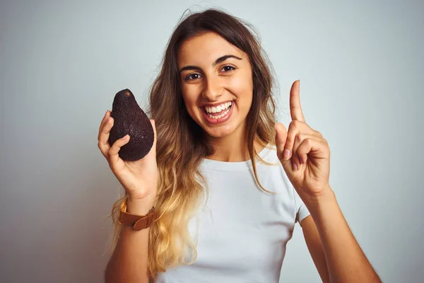 Jeune Belle Femme Mangeant Avocat Sur Fond Gris Isolé Surpris — Photo