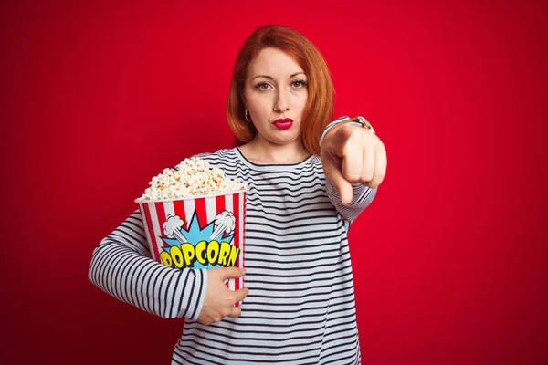 Young Beautiful Redhead Woman Eating Popcorn Red Isolated Background Pointing — Stock Photo, Image