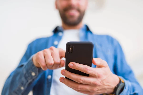 Fechar as mãos do homem usando smartphone e sorrindo — Fotografia de Stock