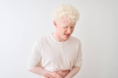 Genç albino sarışın adam rahat t-shirt mide üzerinde el ile izole beyaz arka plan üzerinde duran giyiyor çünkü hazımsızlık, ağrılı hastalık duygusu. Ağrı kavramı.