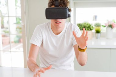 Genç adam eğleniyor evde sanal gerçeklik gözlüklü
