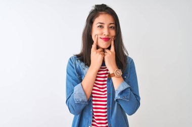 İzole beyaz arka plan üzerinde çizgili t-shirt ve denim gömlek giyen genç Çinli kadın açık ağız ile gülümseyerek, parmakları işaret ve neşeli gülümseme zorluyor
