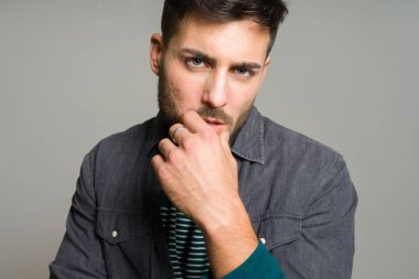 Yakışıklı delikanlı possing ve modelleme gri izole arka plan üzerinde