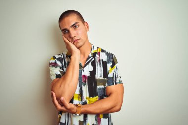 Beyaz izole arka plan üzerinde yazlık gömlek giyen genç yakışıklı adam yorgun görünümlü ve çapraz kolları ile depresyon sorunları ile sıkılmış düşünme.