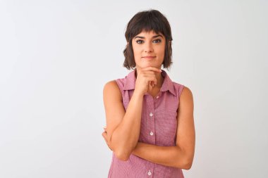 Kırmızı yazlık gömlek giyen genç güzel kadın izole beyaz arka plan üzerinde duran çapraz kolları ve çene üzerinde kaldırdı el ile gülümseme ile kameraya emin bakıyor. Olumlu düşünme.