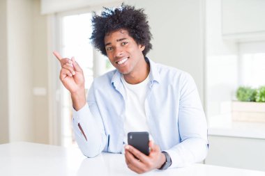 Cep telefonu kullanarak Afrika Amerikan adam çok mutlu yan el ve parmak ile işaret