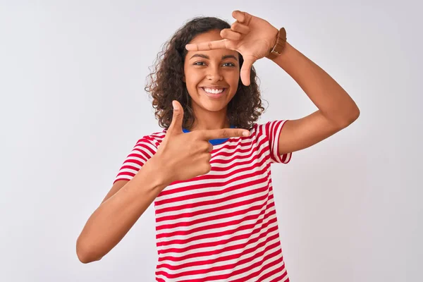 赤いストライプのTシャツを着た若いブラジル人女性は 孤立した白い背景の上に立って 幸せそうな顔で手と指でフレームを作って微笑んでいます 創造性と写真のコンセプト — ストック写真