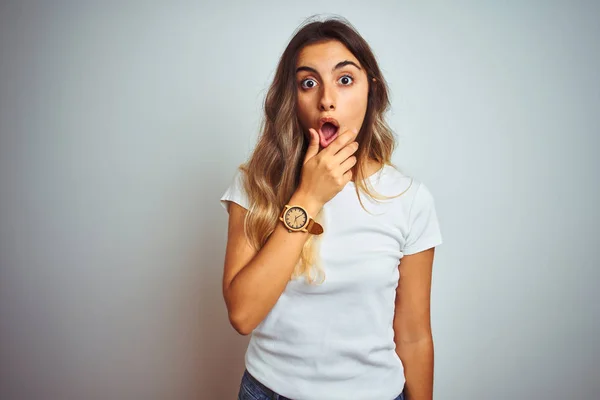 Young beautiful woman wearing casual white t-shirt over isolated background Looking fascinated with disbelief, surprise and amazed expression with hands on chin