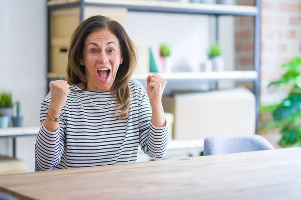 Donna Anziana Mezza Età Seduta Tavola Casa Festeggiare Sorpreso Stupito — Foto Stock