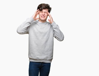 Genç yakışıklı sportif adam kazak giyiyor çünkü umutsuz ve stresli baş ağrısı acı izole arka plan üzerinde ağrı ve Migren. Ellerini kafasına.