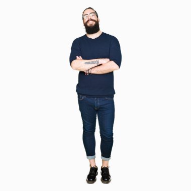 Uzun saç ve sakal ile gülümseyen bardakları mutlu yüz giyen genç hipster adamla silah kameraya bakarak geçti. Olumlu bir kişi.