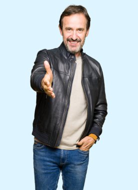 Siyah deri giyen orta yaş yakışıklı adam tebrik ve davet edici olarak gülümseyen dostu sunan karşılıklı ceket. Başarılı iş.