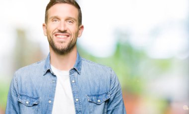 Denim ceket mutlu ve güzel bir gülümseme ile yüzünde sakal ve mavi gözlü yakışıklı adam. Şanslı kişi.