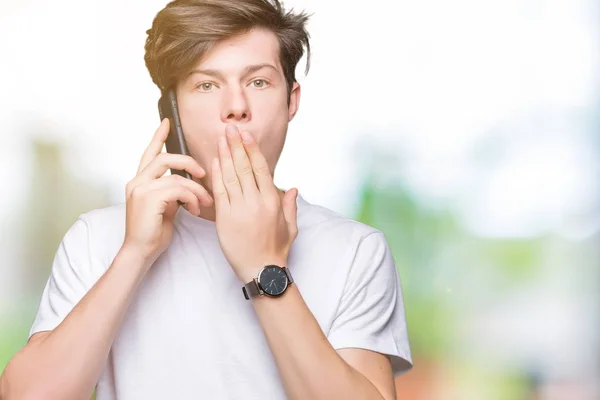 Mladý Muž Mluvil Smartphone Izolované Pozadí Kryt Ústa Rukou Šokován — Stock fotografie