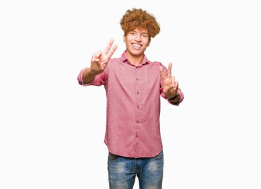 Afro saçlı zafer işareti yapıyor parmak gösterilen kamera seyir gülümseyen genç yakışıklı iş adamı. İki numaralı.