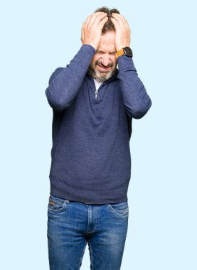 Çünkü çaresiz ve stresli baş ağrısı acı bir kazak giyen orta yaş yakışıklı adam ağrı ve migren. Ellerini kafasına.