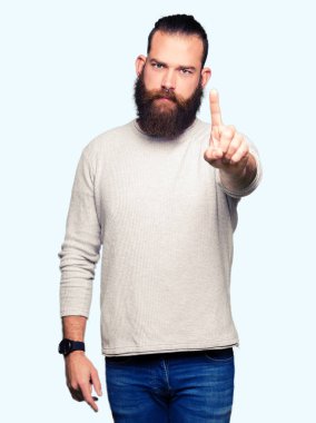 Casual kazak giyen genç sarışın adam işaret parmağını ve kızgın ifade ile