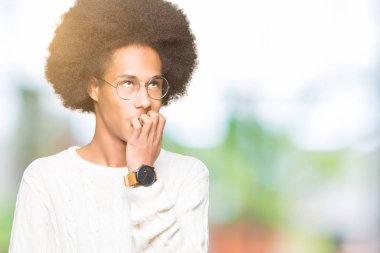 Afrikalı-Amerikalı genç afro saçlı gözlüklü stresli ve gergin elle çivi ısırma ağzına bakıyor. Anksiyete sorunu.