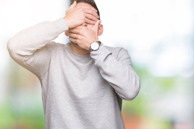 Yakışıklı delikanlı izole arka plan kaplaması gözler ve ağız el ile üzerinden sweatshirt giyen şaşırttı ve şok. Duygu gizleme