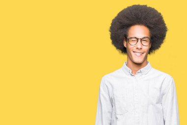 Seksi bir ifadeyle, neşeli ve mutlu yüzünü kameraya bakarak göz kırpıyor afro saç gözlük ile genç Afro-Amerikan adam.