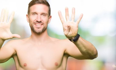 Yakışıklı gömleksiz adam çıplak göğüs gösteren ve parmakları ile işaret ederken emin ve mutlu gülümseyerek dokuz numara.