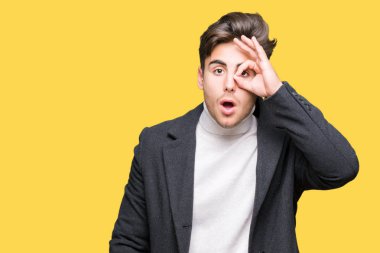 Genç zarif adam izole arka plan üzerinde kış ceket giyen sürpriz yüz, göz parmaklar ile bakarak şok ok jest yapıyor. İnanılmaz ifade.