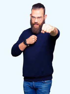 Savaşmak için saldırgan ve kızgın saldırı, tehdit ve şiddet gözlük ve balıkçı yaka kazak kum yumruk giyen genç sarışın adam