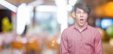 Genç yakışıklı iş adamı izole arka plan korkuyor ve şok sürpriz ifade, korku ve heyecan yüz üzerinden.