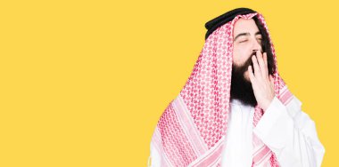 Arap iş adamı geleneksel keffiyeh giymiş uzun saçlı eşarp sıkılmış el ağzıyla kapsayan yorgun esneme. Restless ve uyku hali.