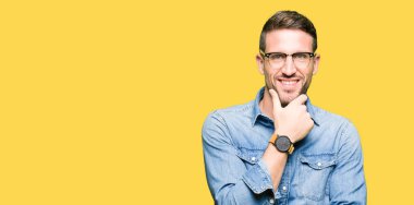 Yakışıklı adam gözlüklü emin çapraz kollar ve çeneme kaldırdı el ile gülümseme ile kameraya bakıyor. Pozitif düşünce.