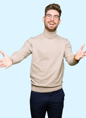 Kamera ile gülümseyen bakarak genç yakışıklı iş adam gözlük silah sarılmak için açın. Neşeli ifade kucaklayan mutluluk.