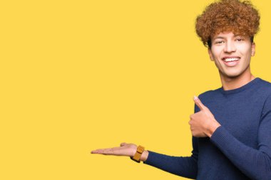 Genç yakışıklı adam ile afro saç gösteren palmiye el ve yapıyor ok jest ile thumbs yukarı, gülümseyen mutlu ve neşeli