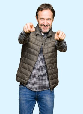 Sen ve kamera için orta yaş yakışıklı adam giyen kış yelek işaretleme olumlu ve neşeli gülümseyen parmakları ile